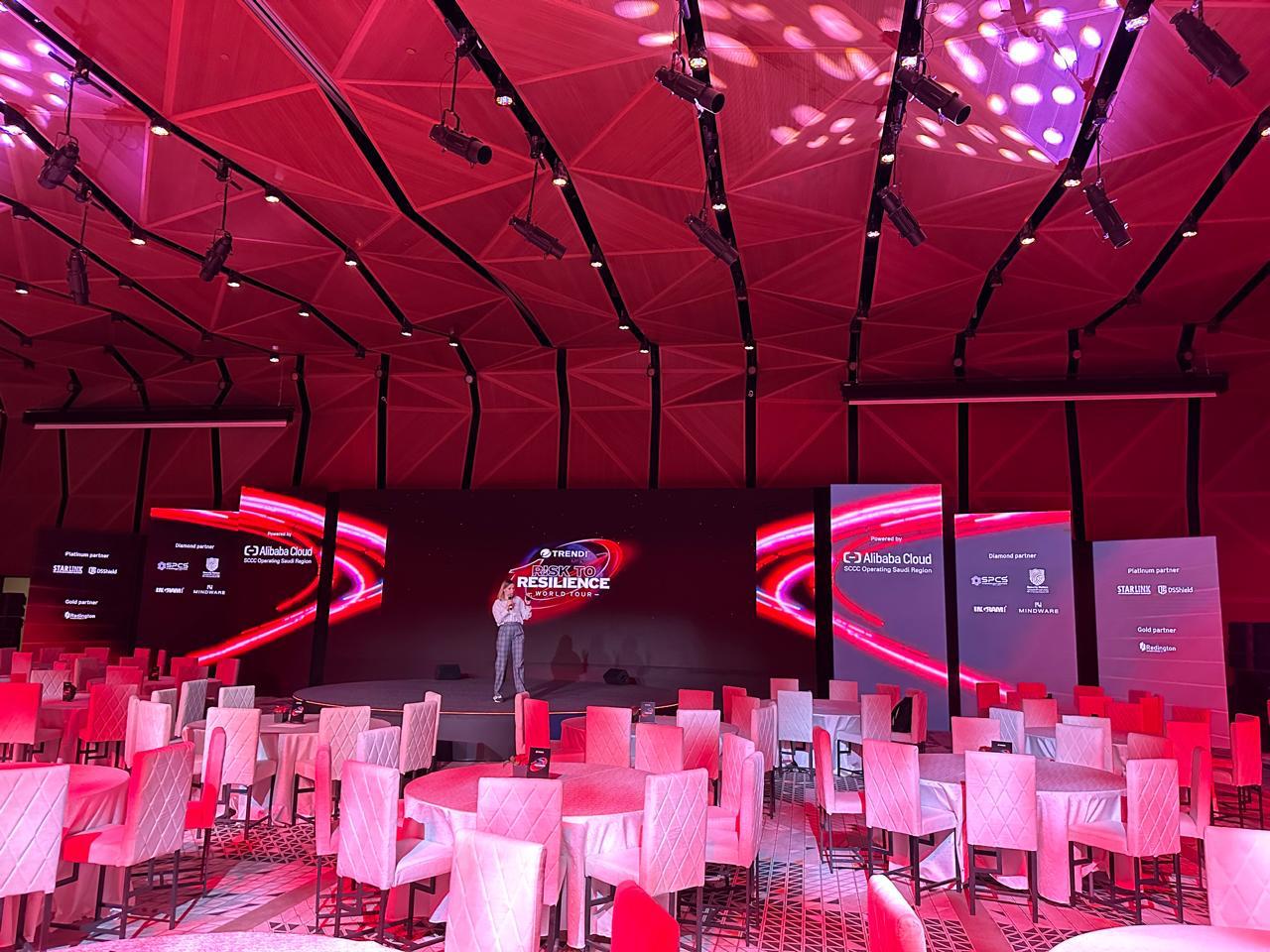 Trend Micro Risk to Resilience World Tour stage under a red-lit faceted ceiling.