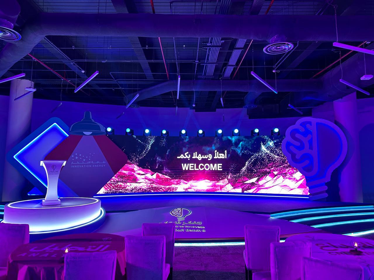 Innovation Energy welcome stage built around an oversized lamp and bulb motif.